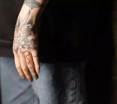 Intricate tattoo on the left hand of a man